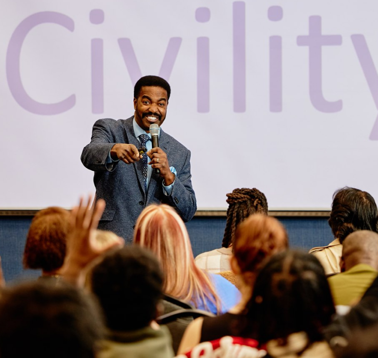 MAN WITH MICROPHONE SPEAKING AT CONFERENCE